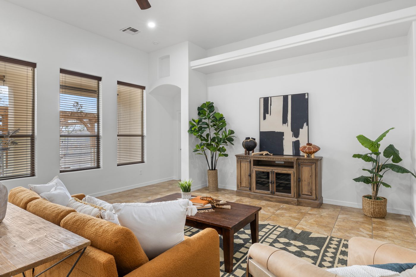Living room with caramel sofa, abstract art and indoor plants, Cymbeline