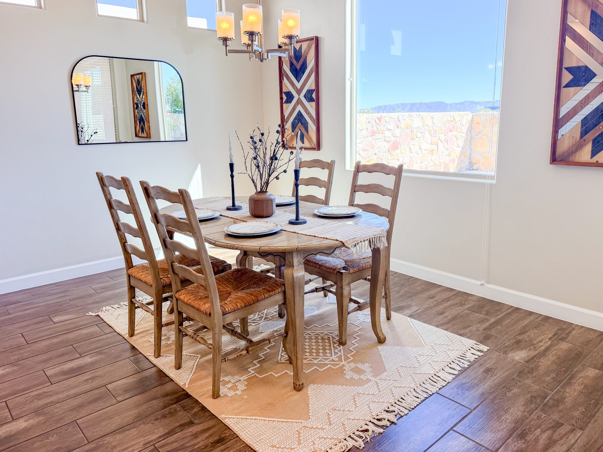 Dining nook with wood chairs, arched mirror and desert window, Electra Ave