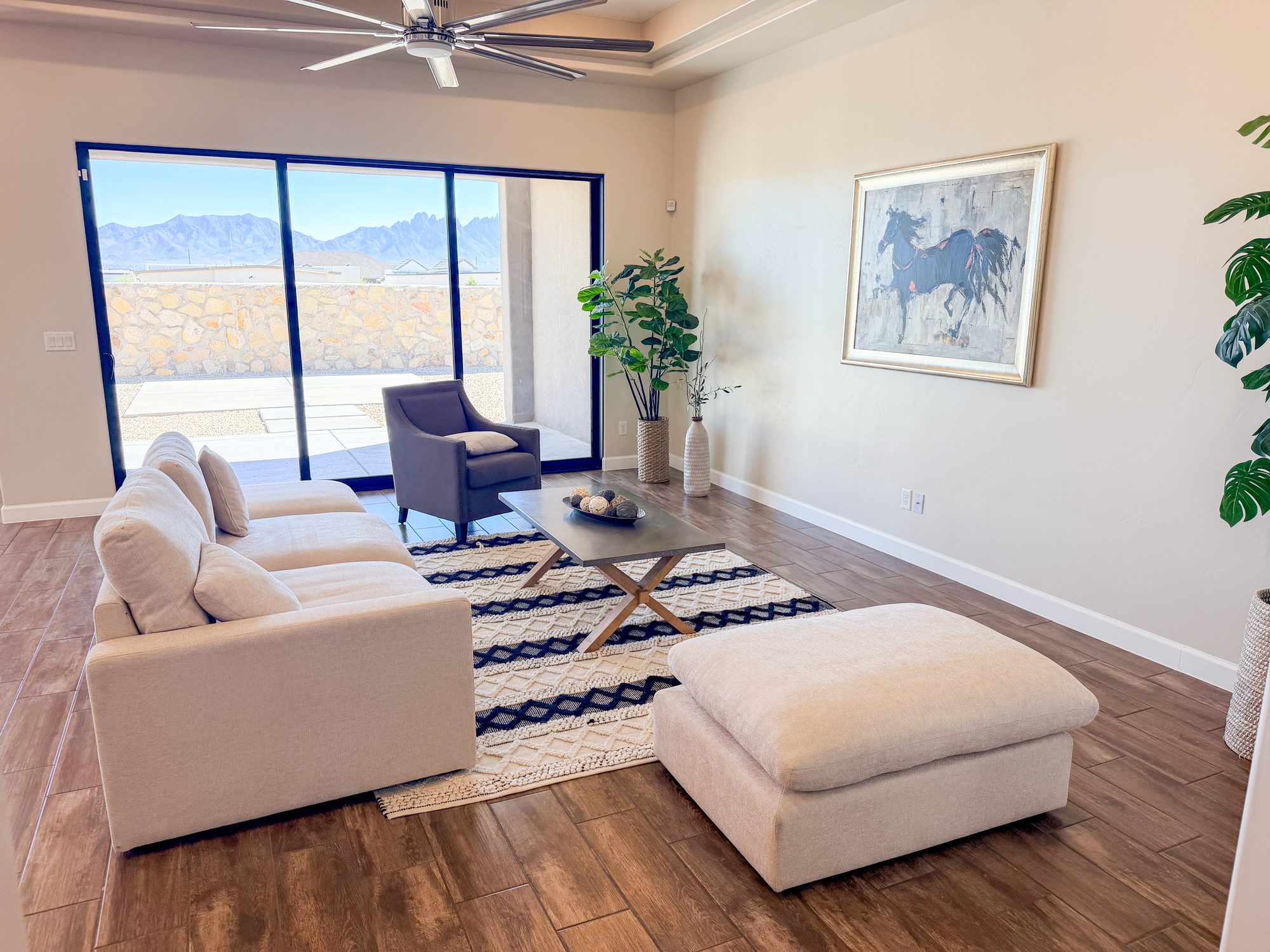 Living room with horse painting, ottoman and mountain view through glass doors, Electra Ave